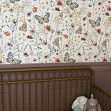 Vintage nursery with floral butterfly peel and stick wallpaper and purple accent walls