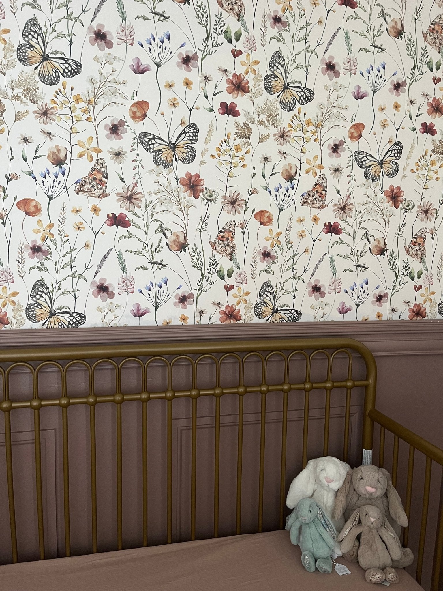 Vintage nursery with floral butterfly peel and stick wallpaper and purple accent walls