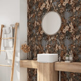 A bathroom featuring a round mirror above a white basin, set against a wall adorned with classic floral wallpaper in earth tones.
