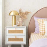 Flowers in cream beige wallpaper in a room with a gold lamp and pampas