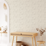 Entryway with cute floral wallpaper behind a boho style entry desk.