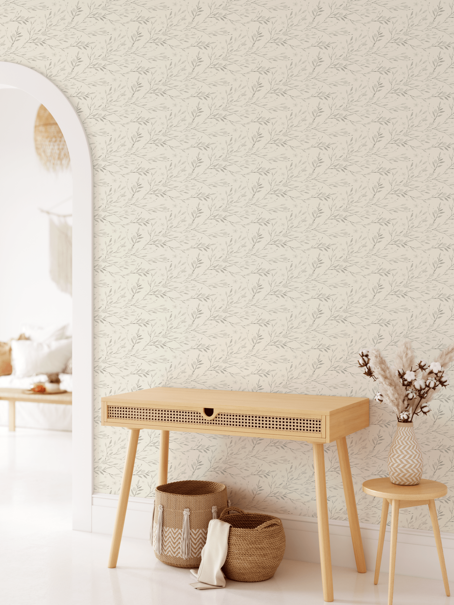 Entryway with cute floral wallpaper behind a boho style entry desk.