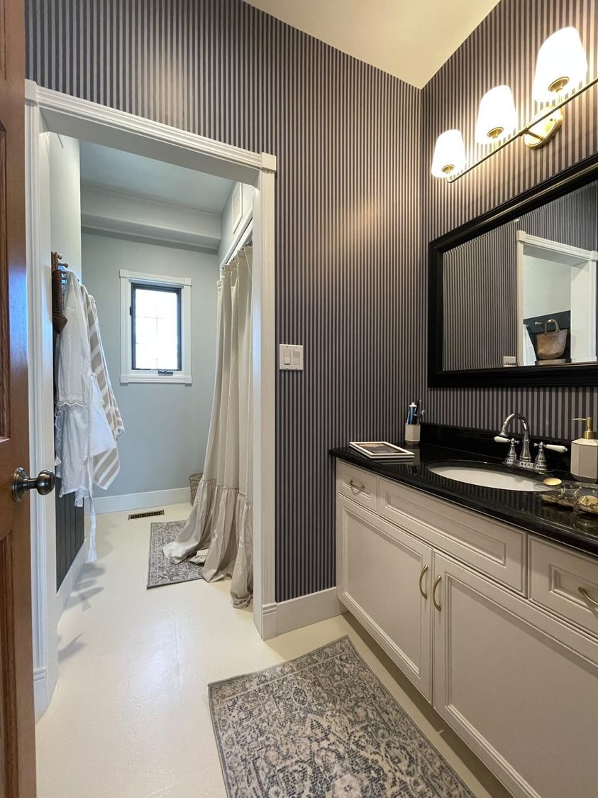 Country club chic bathroom, featuring a deep blue striped wallpaper