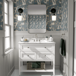 A bathroom with the walls covered in a woodland-themed wallpaper showcasing white rabbits, trees, and birds on a blue background.