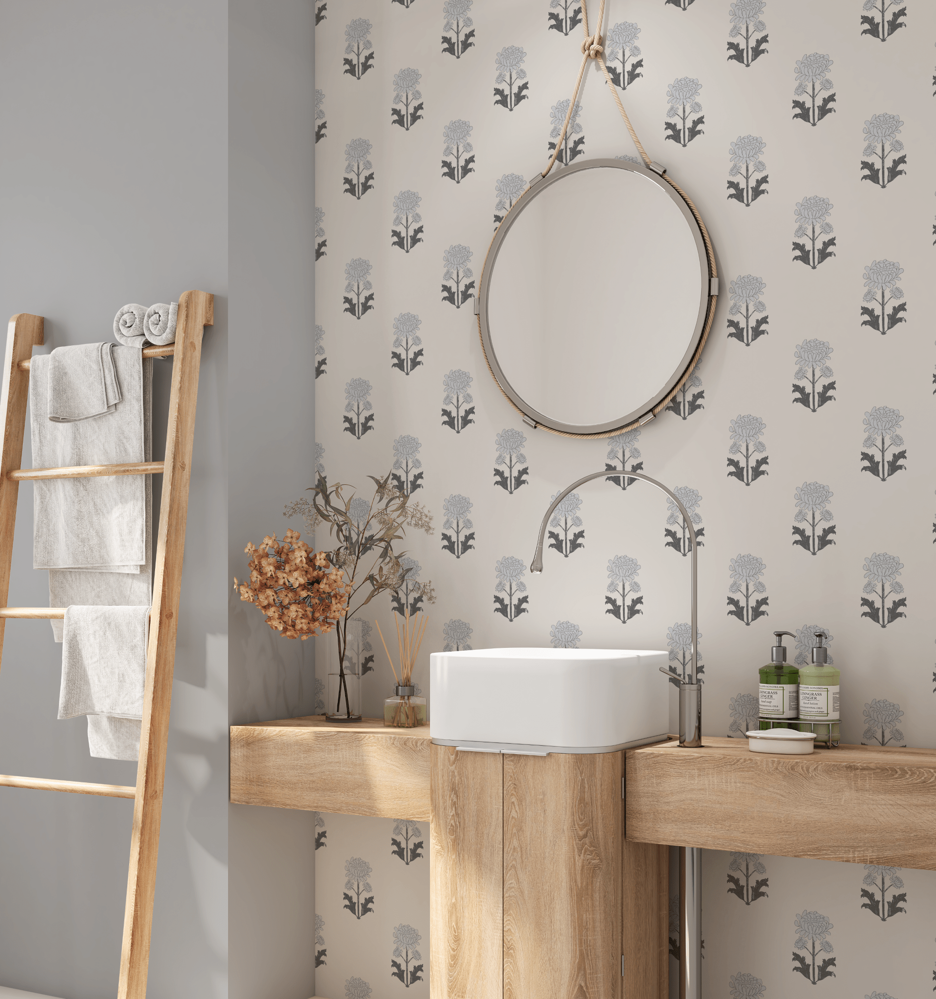 A modern bathroom with a wall adorned in floral blueprint self-adhesive wallpaper. A round mirror hangs above a wooden vanity with a white basin, complemented by dried flowers and soft towels on a ladder rack beside it