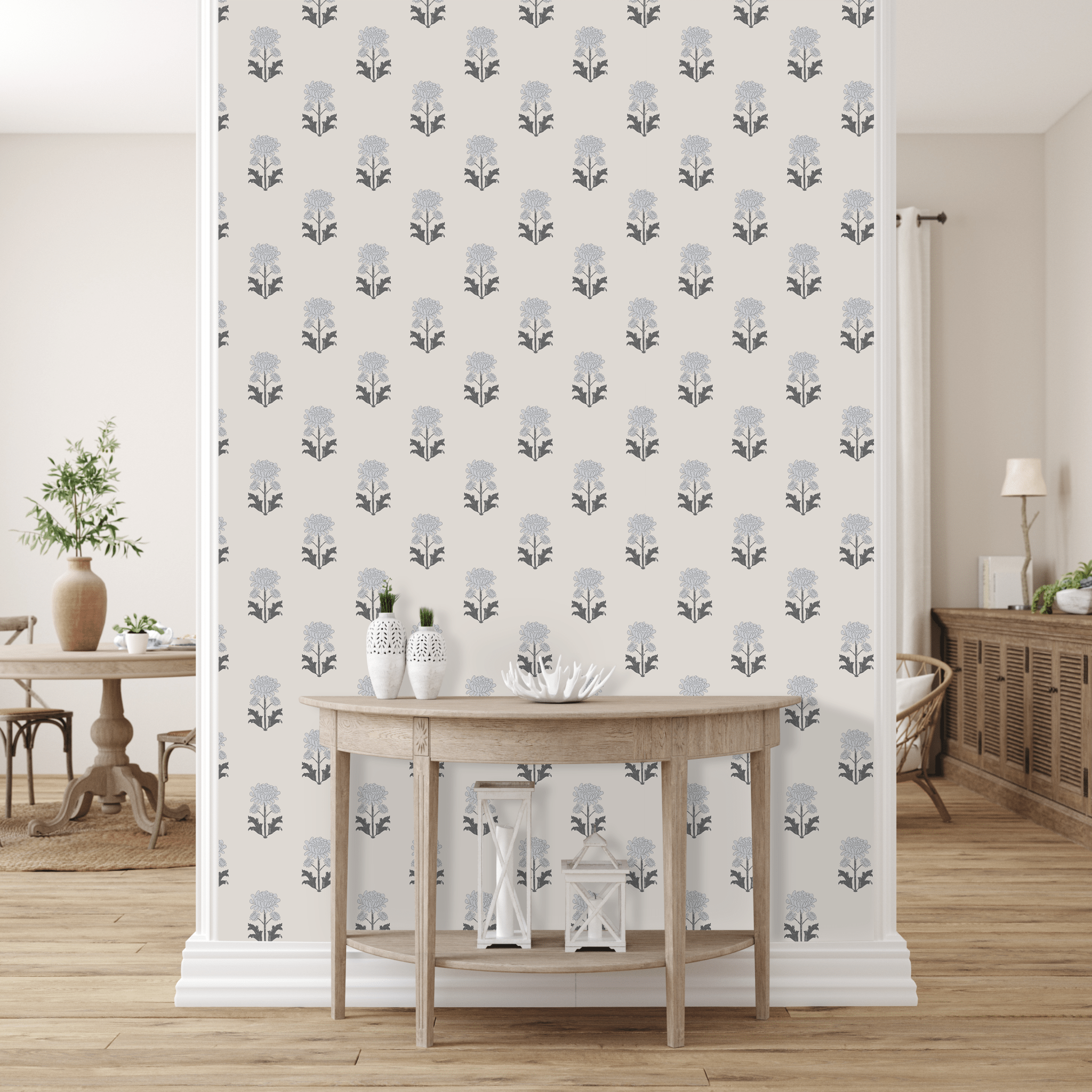 A stylish room with a wall covered in floral blueprint peel and stick removable wallpaper. A wooden table with white vases and a coral piece sits in front, and a dining area is subtly visible in the background