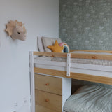 A cozy corner of a child's bedroom with a pine bunk bed, forest green floral wallpaper, and assorted plush toys and cushions.