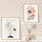 Pink floral wallpaper in a child's room with art, toys, and decorative garland.