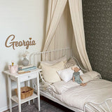 Simplistic child's room with neutral decor and dark green peel and stick wallpaper