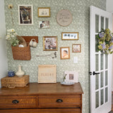 Office wall with rustic decor and sage green wallpaper