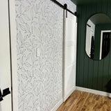 Minimal floral peel and stick wallpaper in bedroom with green walls and natural wood flooring