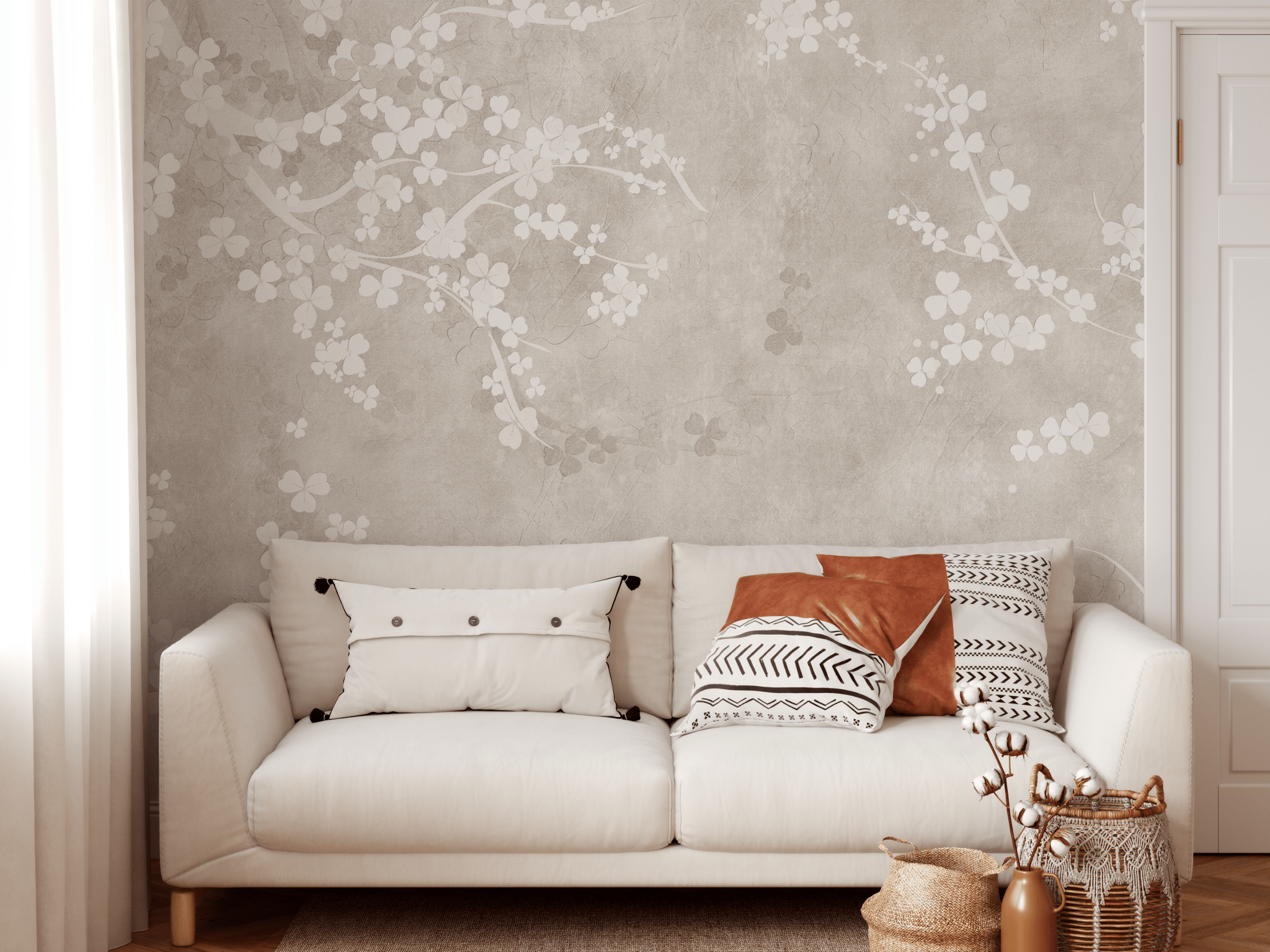 A cozy living space with a beige floral fresco wall mural, cream sofa with decorative pillows, and woven accessories