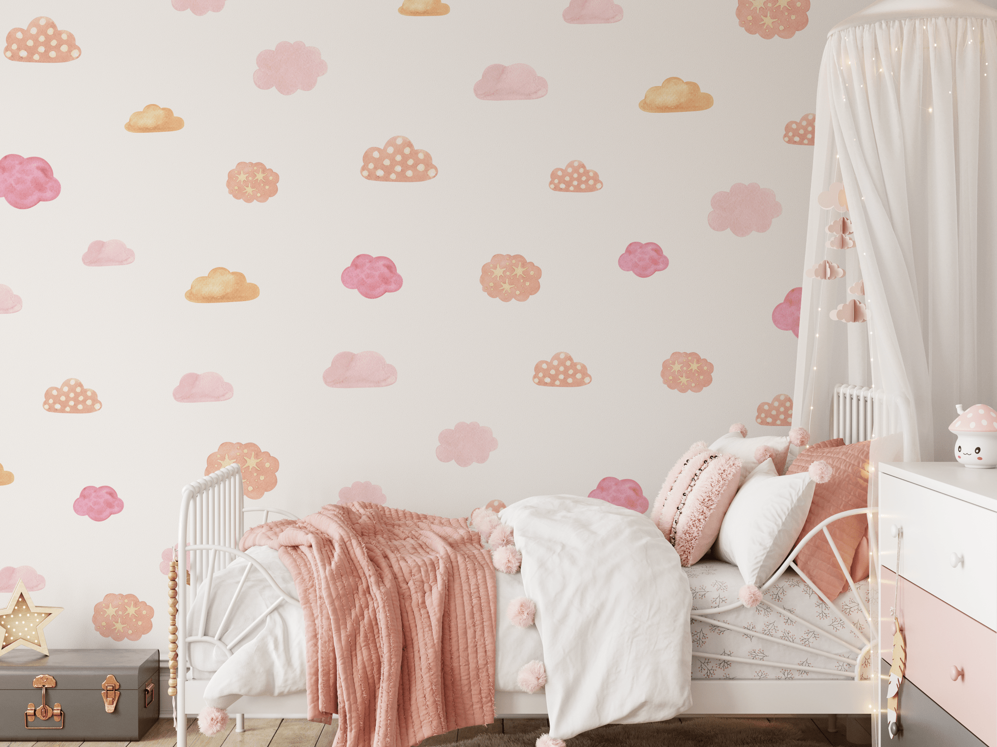 Interior of a girl's bedroom featuring walls with pink and orange watercolor cloud stickers, a cozy bed with pink bedding, and a white canopy with fairy lights