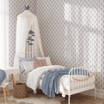 A child's bedroom featuring high-quality wallpaper with a hydrangea pattern. There's a white bed with a canopy, blue accents, and playful decor.