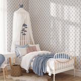 A child's bedroom featuring high-quality wallpaper with a hydrangea pattern. There's a white bed with a canopy, blue accents, and playful decor.