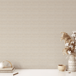 A clean and minimal workspace against a backdrop of white-washed rattan weave wallpaper, with a productivity planner and a vase of dried flowers on the desk for a touch of boho decor.