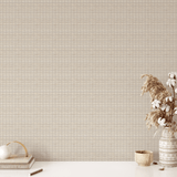 A clean and minimal workspace against a backdrop of white-washed rattan weave wallpaper, with a productivity planner and a vase of dried flowers on the desk for a touch of boho decor.