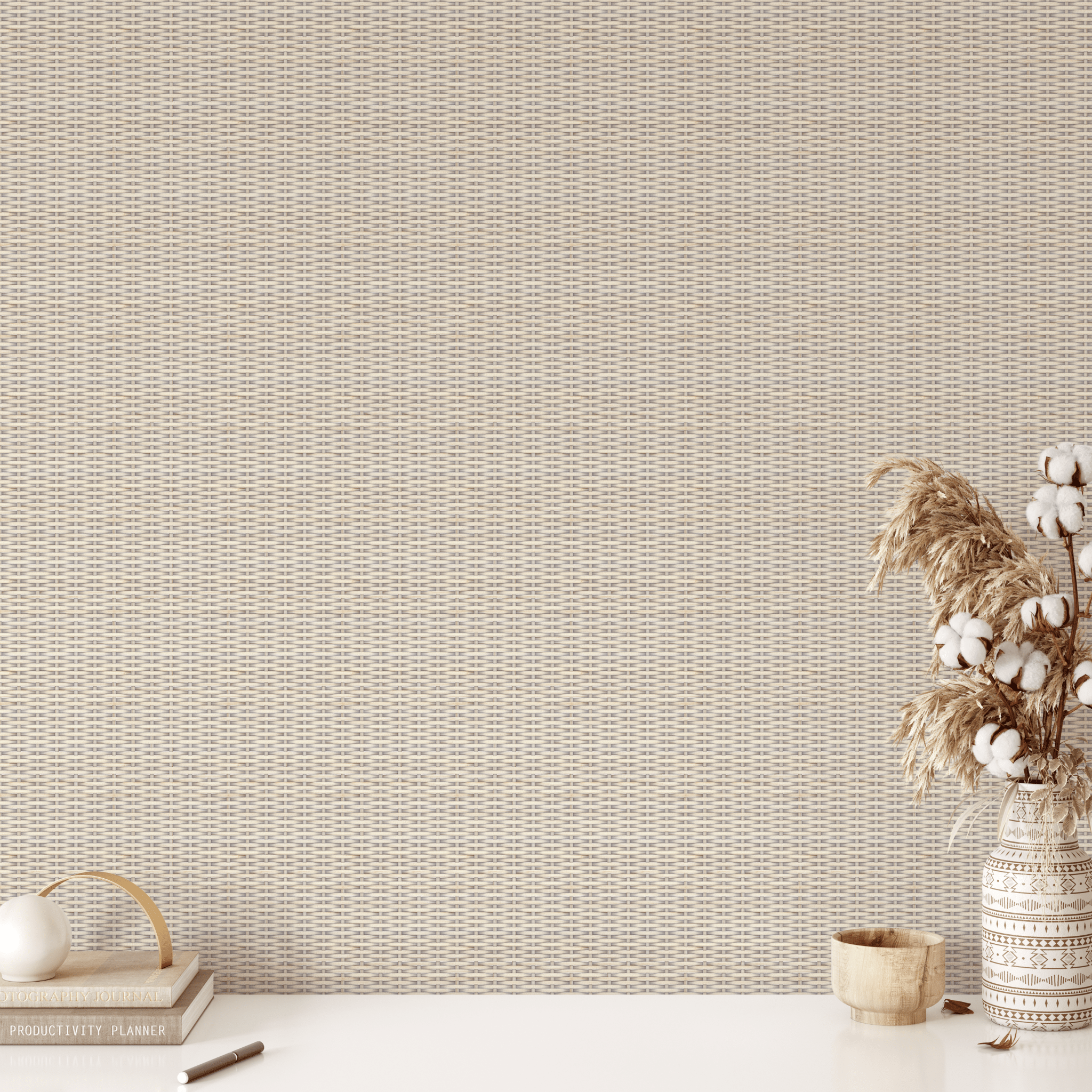 A clean and minimal workspace against a backdrop of white-washed rattan weave wallpaper, with a productivity planner and a vase of dried flowers on the desk for a touch of boho decor.