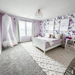 Purple themed girls bedroom with floral self adhesive, removable purple floral wallpaper.