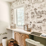 Gorgeous home office with natural wood colours and peel and stick toile de jouy wallpaper