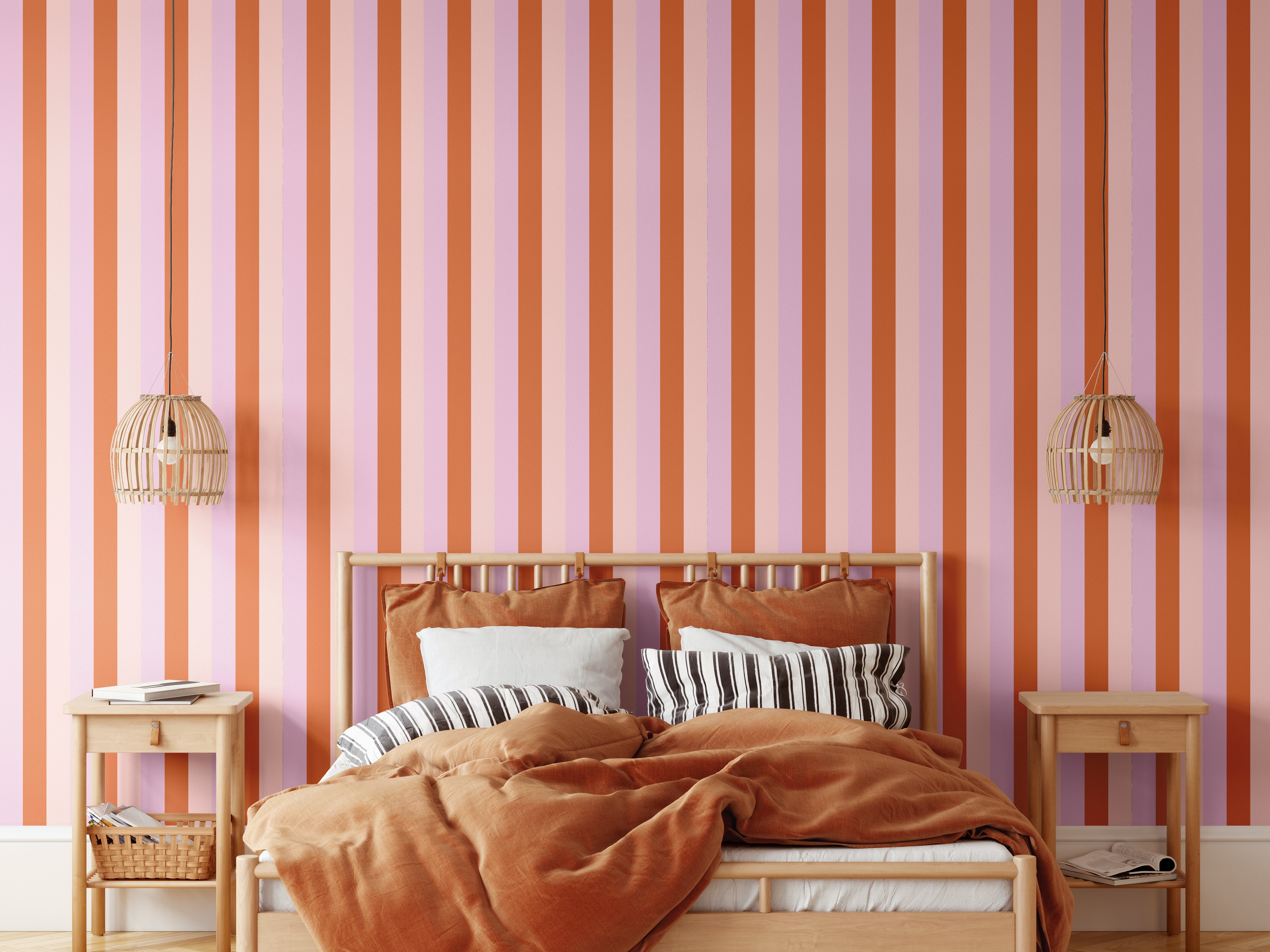 Taffy striped wallpaper in warm-toned bedroom with cane pendants and rust bedding