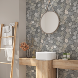 Flagstone tile wallpaper in a modern bathroom, rustic stone wall behind round mirror and wood vanity