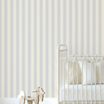 Blue dotted stripe wallpaper in a neutral baby nursery with cream crib, striped bedding, and wooden rocking horse, creating a cozy vintage style