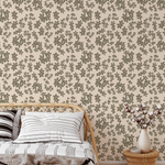 Brush stroke floral wallpaper in neutral beige and olive tones styled in a boho bedroom with rattan furniture