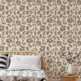 Brush stroke floral wallpaper in neutral beige and olive tones styled in a boho bedroom with rattan furniture