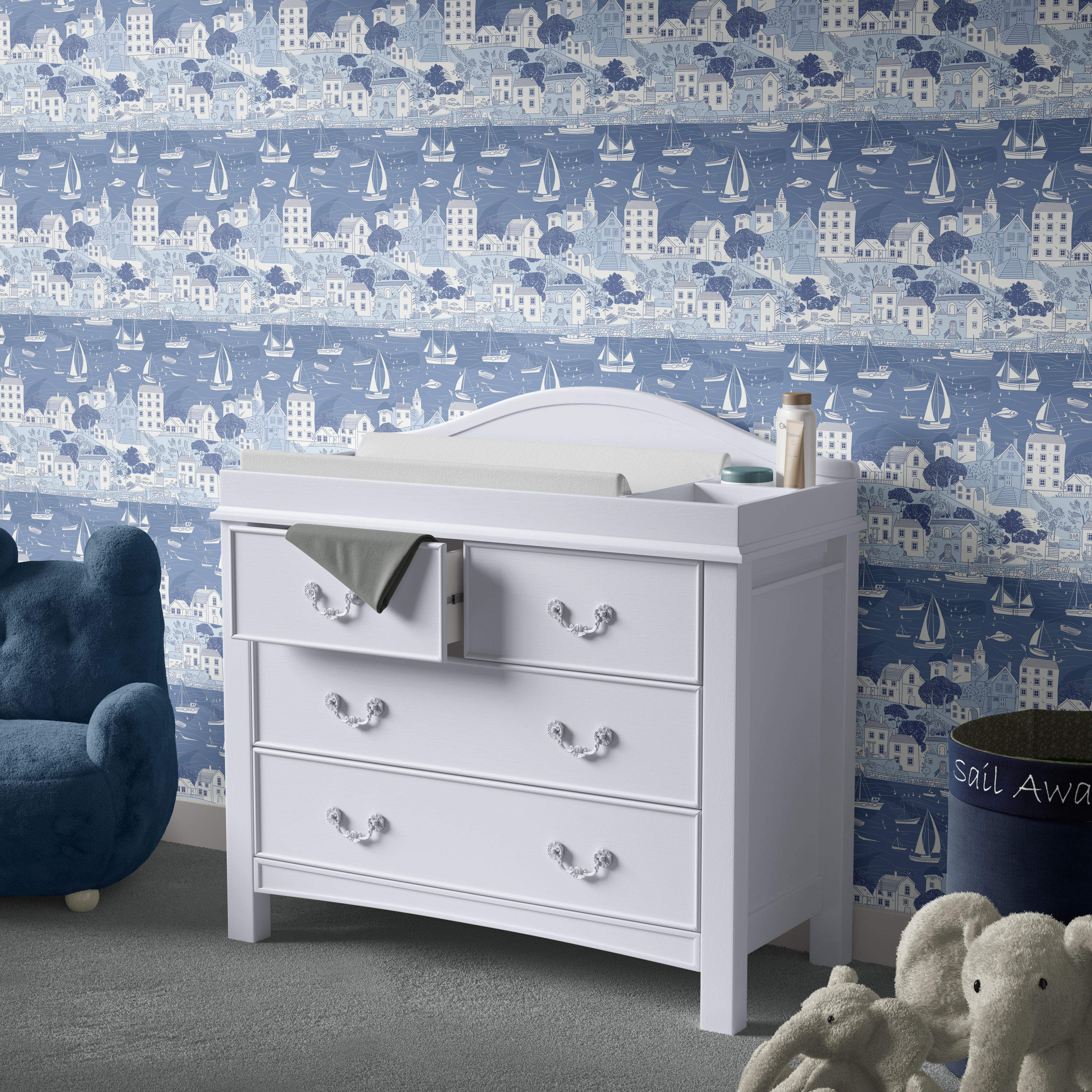 Blue coastal harbor wallpaper behind white nursery dresser with sailboats and seaside village pattern