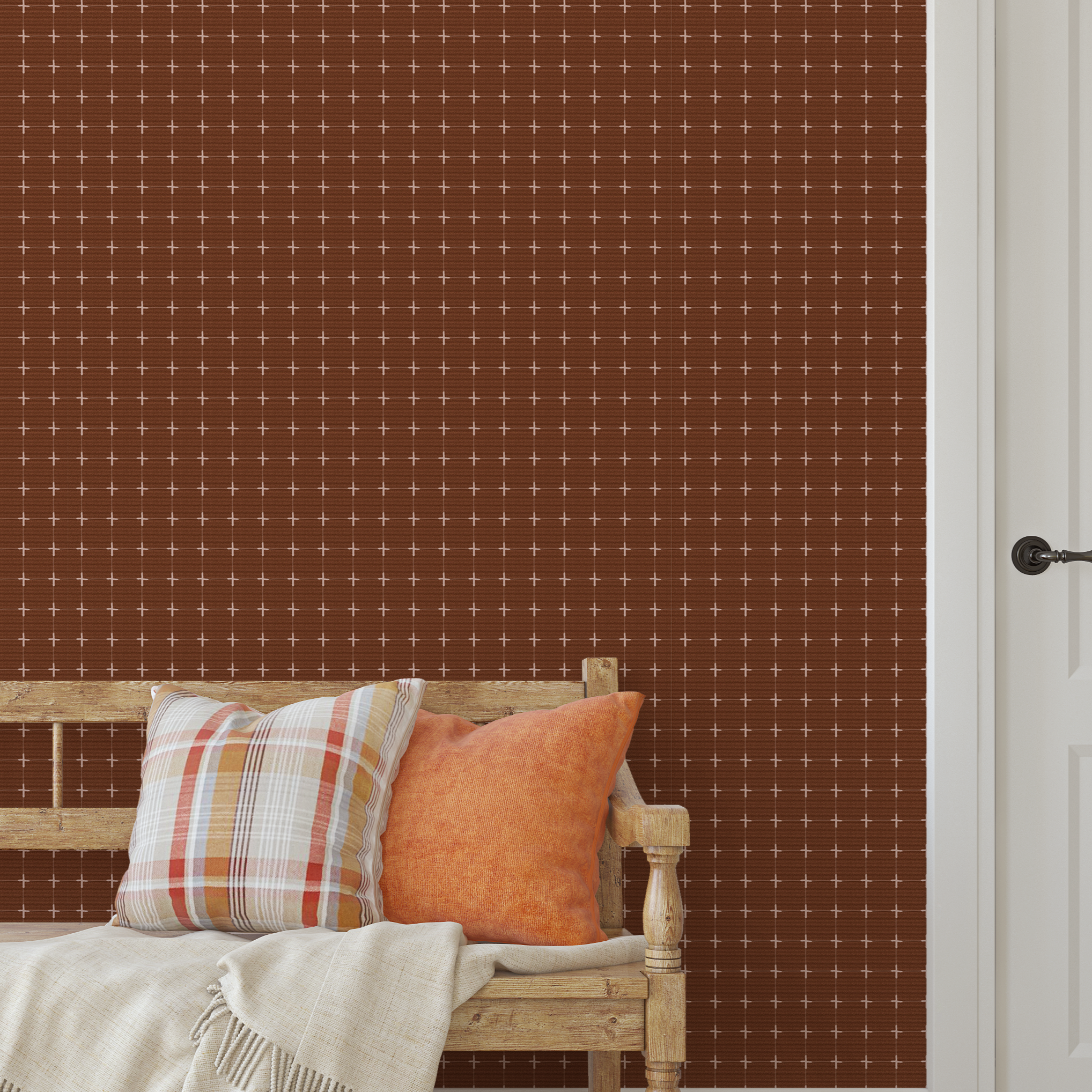 Warm brown grid wallpaper behind a rustic wood bench with orange and plaid pillows