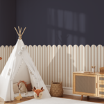 Beige scallop stripe wall panels in kids’ playroom with teepee and giraffe toy.