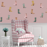 Pink cowgirl boot wall decals in a girls’ room with plaid chair and pastel decor.