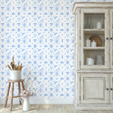 Farmhouse decor with rustic cabinet and Delft tile wallpaper in blue floral pattern.