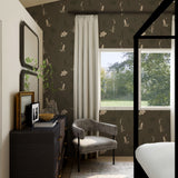 Modern bedroom with dark floral wallpaper, gray armchair, and large window.