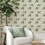 Living room corner with flying duck wallpaper, white armchair, and green pillow