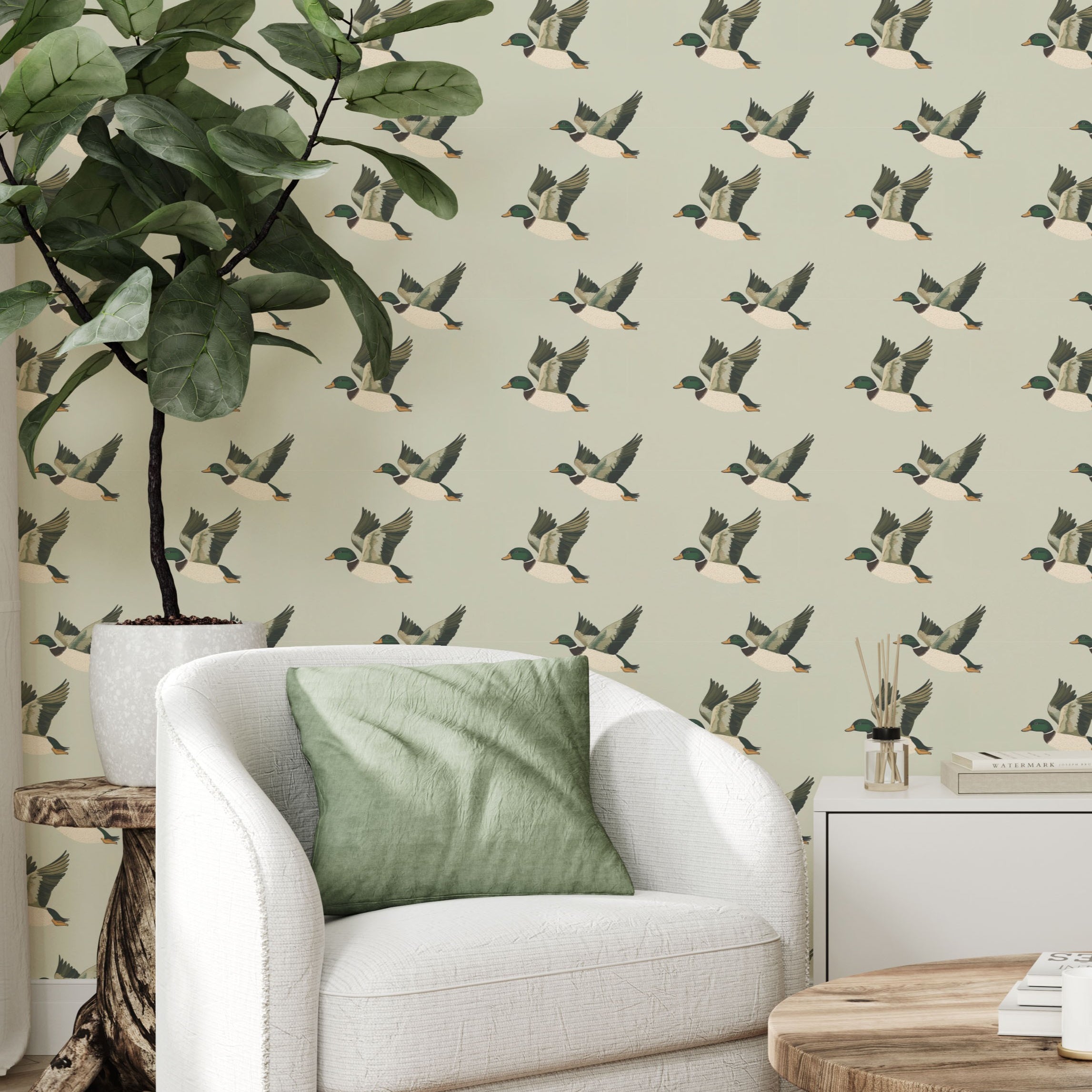 Living room corner with flying duck wallpaper, white armchair, and green pillow