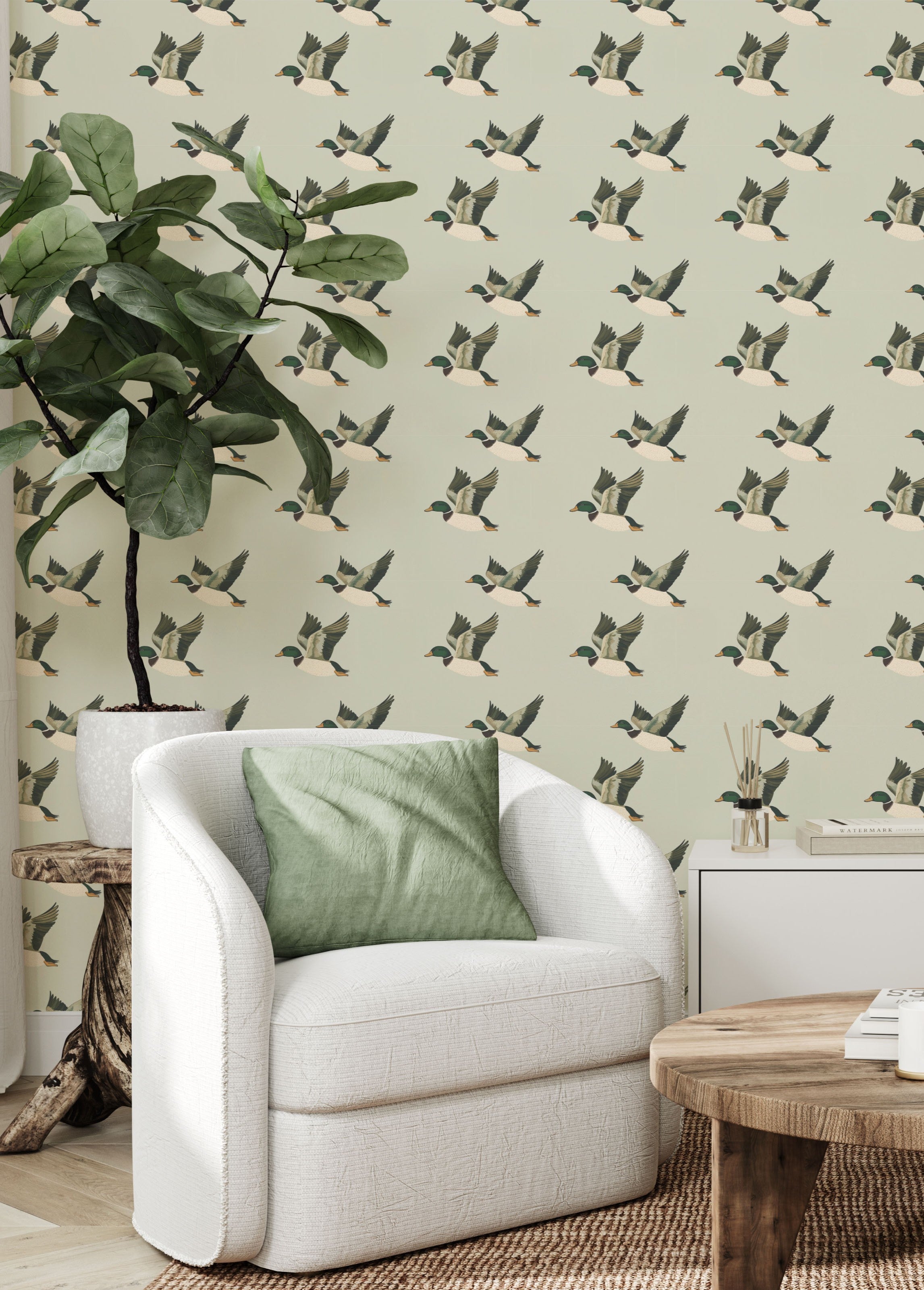 Living room corner with flying duck wallpaper, white armchair, and green pillow