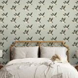 Bedroom with flying duck wallpaper behind rattan headboard and neutral bedding