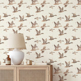 Close-up of goose migration wallpaper with watercolor birds on a cream background
