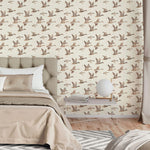 Bedroom with neutral flying geese wallpaper behind tufted headboard and beige bedding