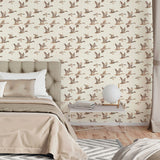 Bedroom with neutral flying geese wallpaper behind tufted headboard and beige bedding