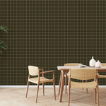 Olive green grid pattern wallpaper styled in dining room with woven chairs and large indoor plant
