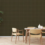 Olive green grid pattern wallpaper styled in dining room with woven chairs and large indoor plant