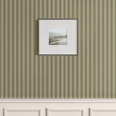 Classic vertical green stripe wallpaper with beige wainscoting and framed coastal photo