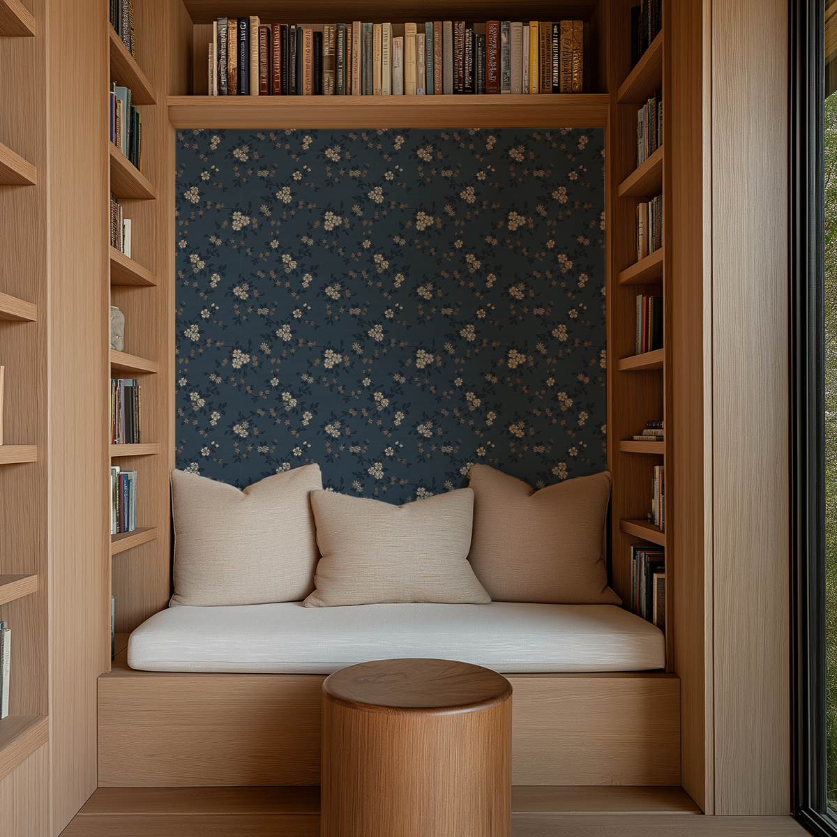 Dark blue cottage floral wallpaper in a cozy built in reading nook with warm wood bookshelves and neutral pillows