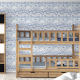 Blue seaside wallpaper behind natural wood bunk beds with matching nautical bedding