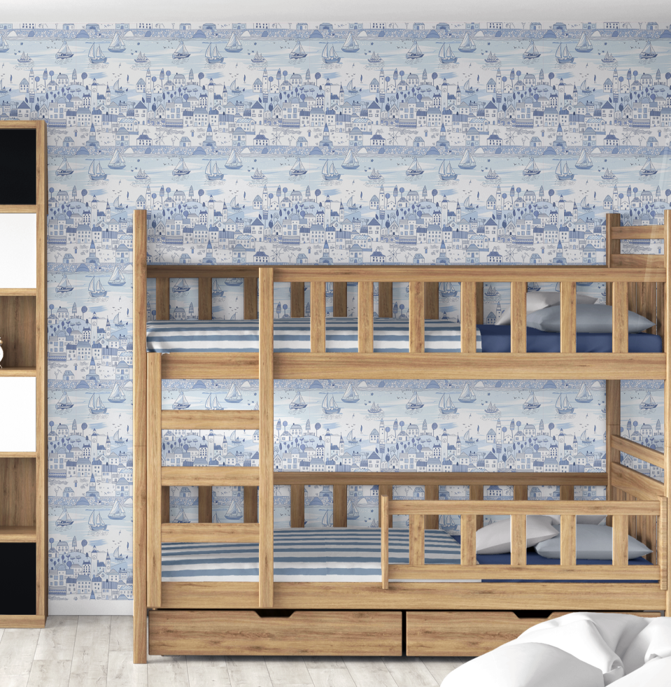 Blue seaside wallpaper behind natural wood bunk beds with matching nautical bedding