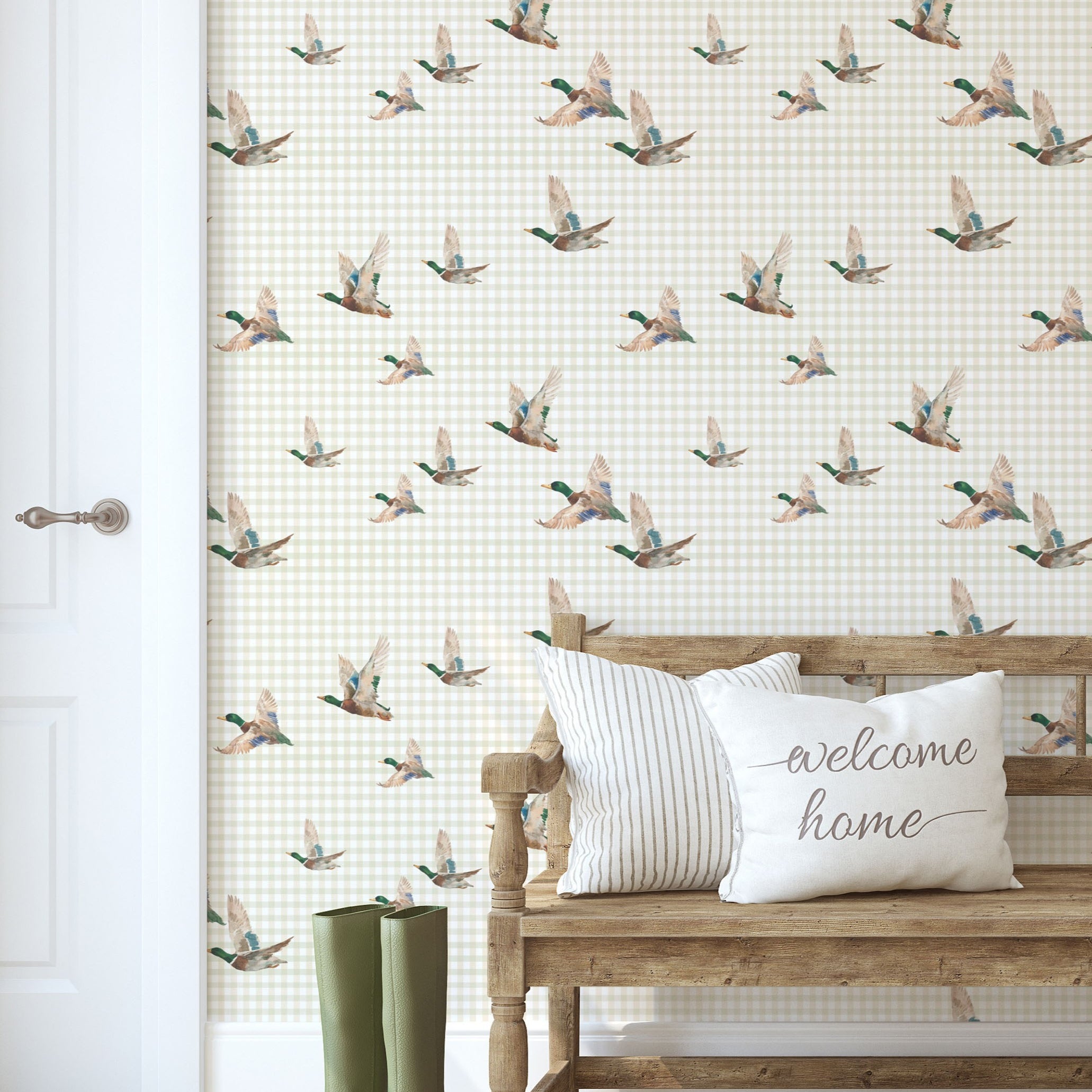 Entryway with mallard duck wallpaper, wooden bench, welcome pillows, and green boots