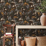 Dark wildflower wallpaper styled in an entryway with natural wood furniture and woven accents